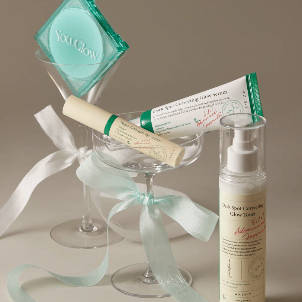 Bild på hudvårdskit från AXIS-Y med ögonserum, serum och toner – elegant placerade i cocktailglas med sidenband, perfekt för en lyxig gåvopresentation.