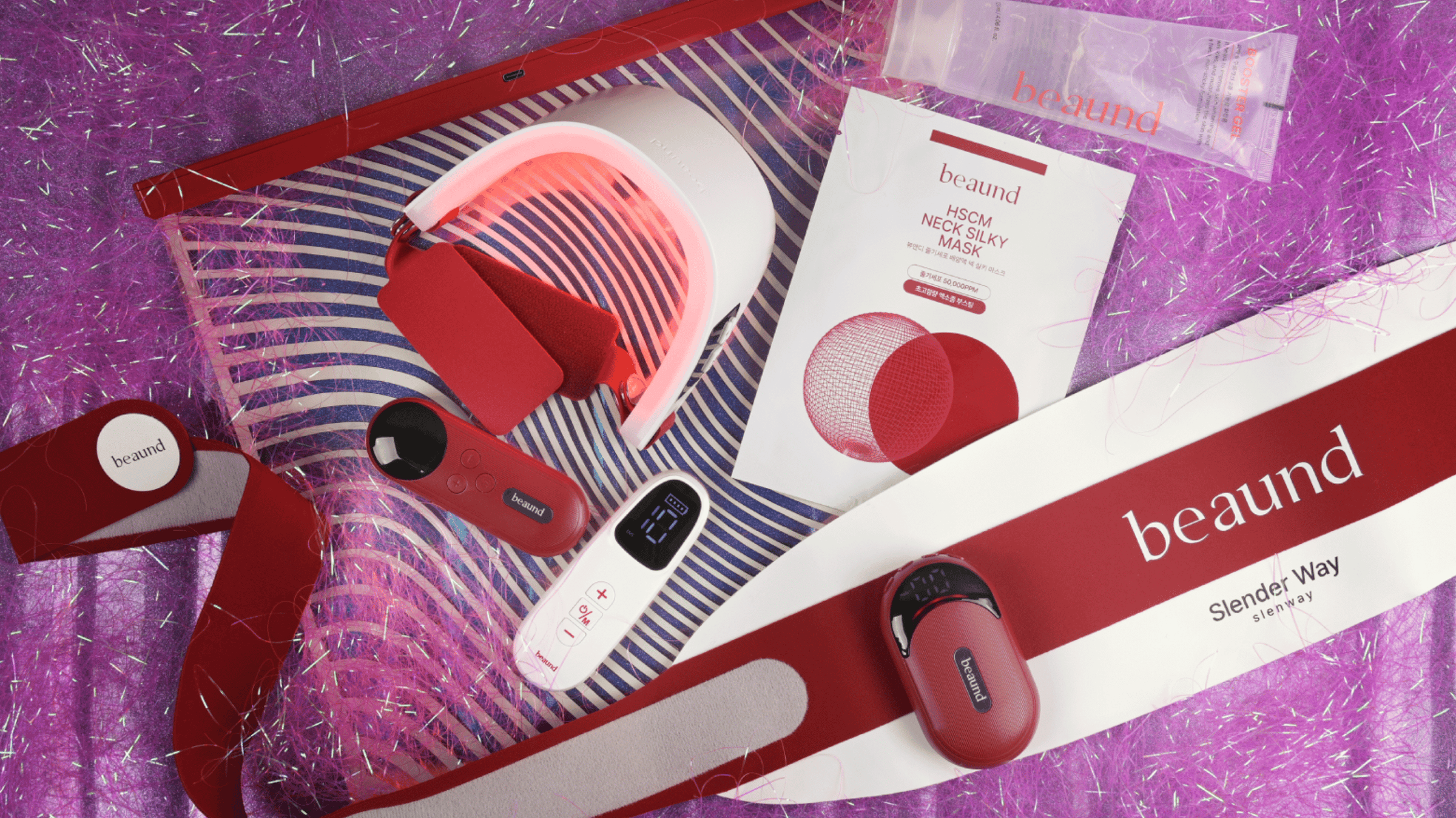 Färgstark flatlay-bild med Beauds skönhets- och wellnessprodukter, inklusive LED-enhet, neck mask och Slimder Way-produkter i röd design mot glittrig lila bakgrund.