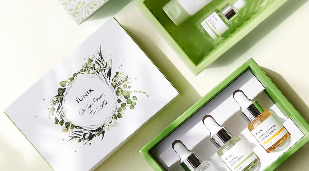 En grön låda med flera kosmetiska produkter från varumärket iUNIK.