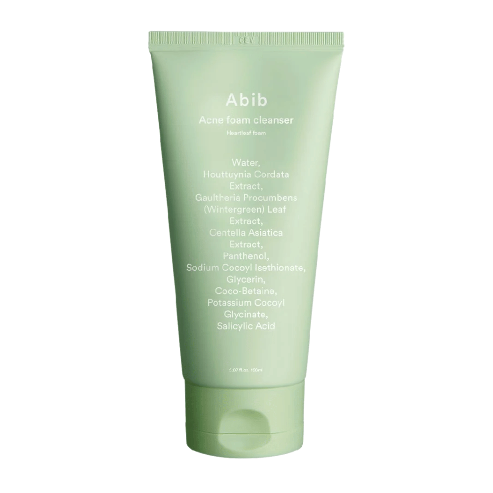 Green tube with Abib Acne Foam Cleanser Heartleaf Foam, showing ingredients like Houttuynia Cordata, Centella Asiatica, and Salicylic Acid printed on the front. The product stands upright against a white background.
