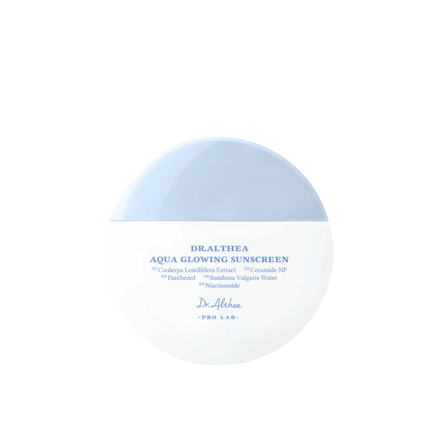 Produktbild av Dr. Althea Aqua Glowing Sunscreen – en rund solskyddskräm i vit och ljusblå förpackning med text i blått som lyfter fram återfuktande ingredienser som niacinamid och ceramider.