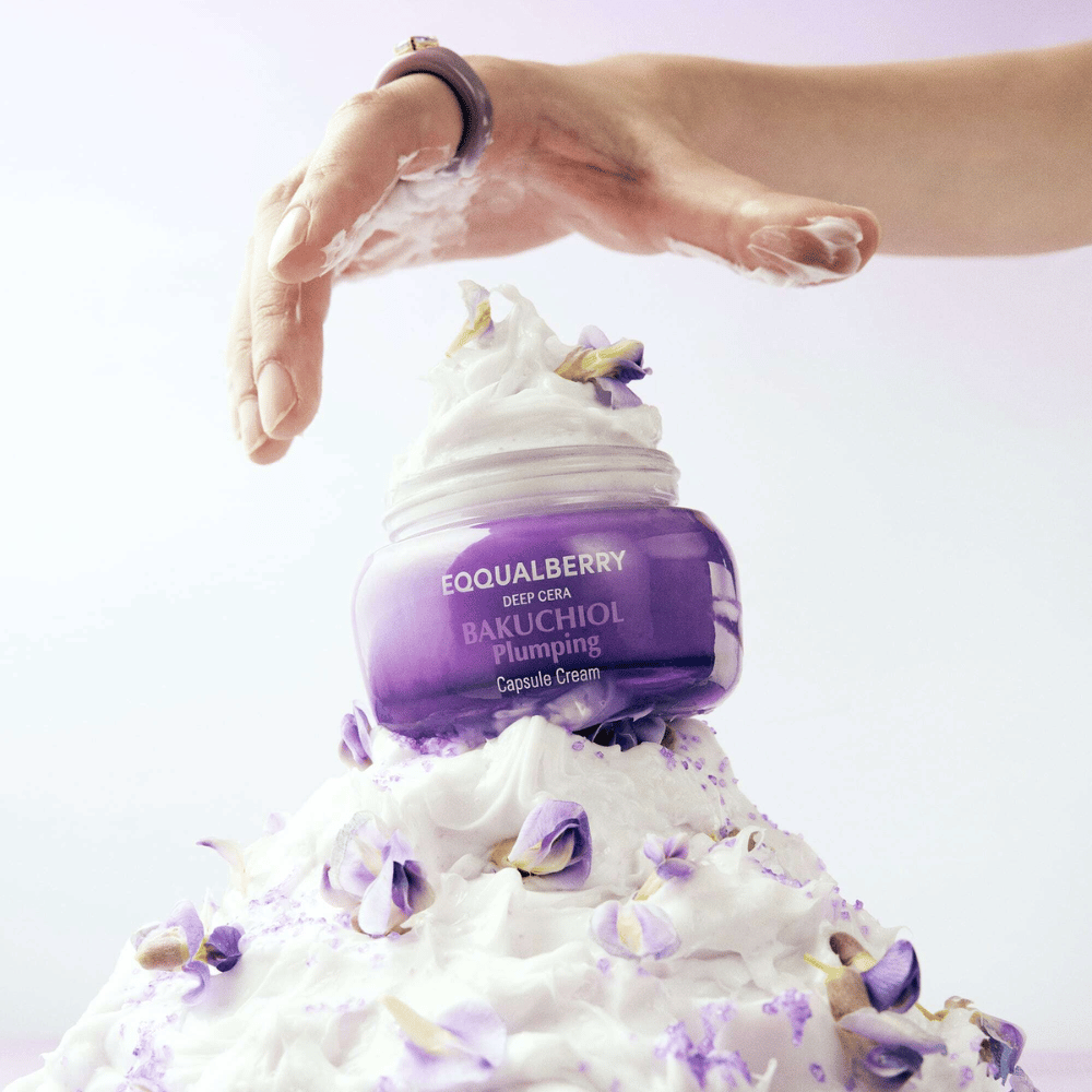 EQQUALBERRY Bakuchiol Plumping Capsule Cream placed on top of a heap of whipped cream with flower petals – symbolizes moisture and care.