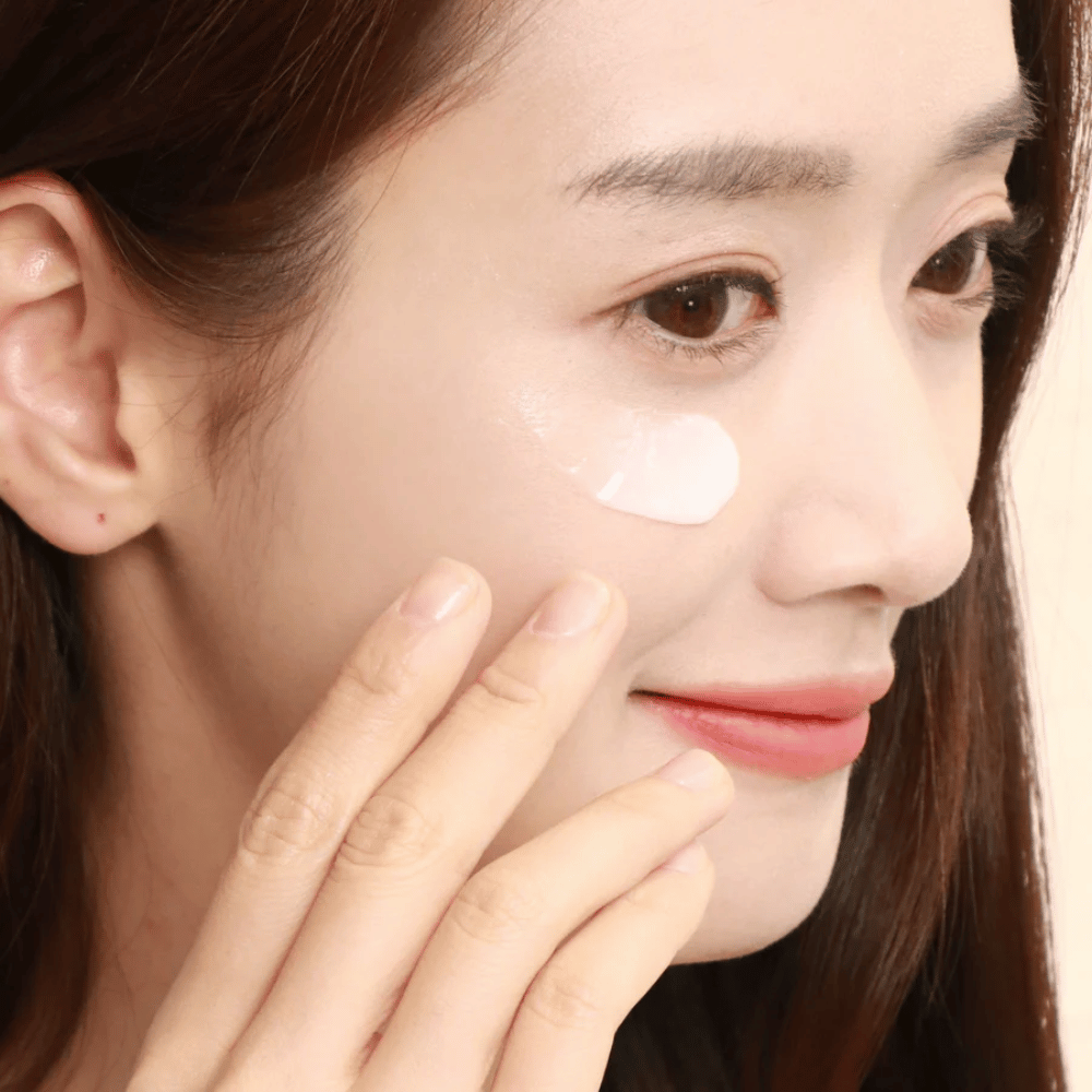 Woman applies eye cream under the eye with fingertips – close-up showing how the product is gently massaged into the skin for hydration and care.