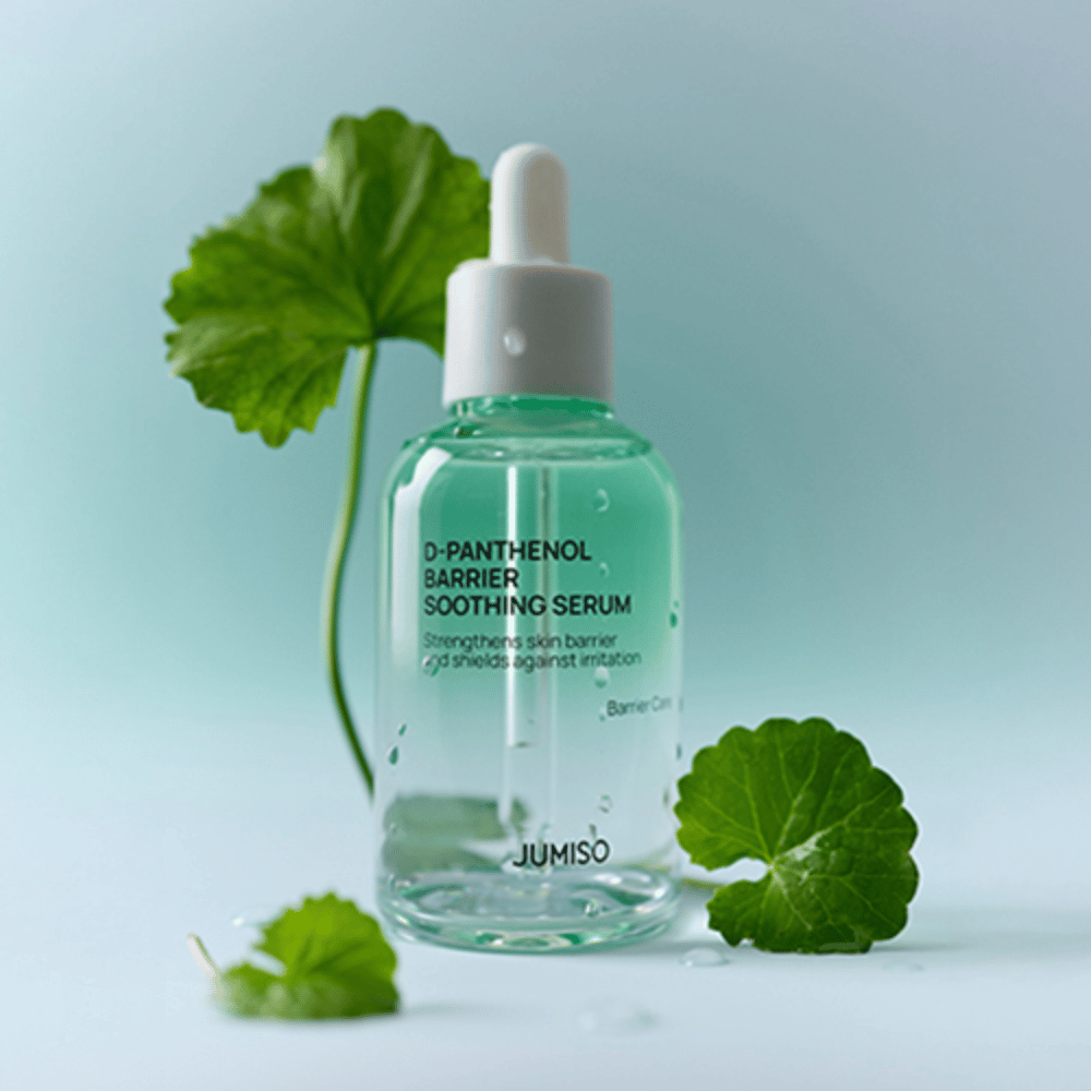 Jumiso D-Panthenol Barrier Soothing Serum in a transparent glass bottle with a pipette, placed with green leaves in the background.