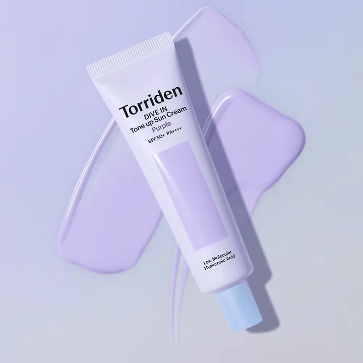 Torriden DIVE IN Tone Up Sun Cream Purple placed on smeared purple cream that emphasizes the tone-evening and radiance-enhancing effect.