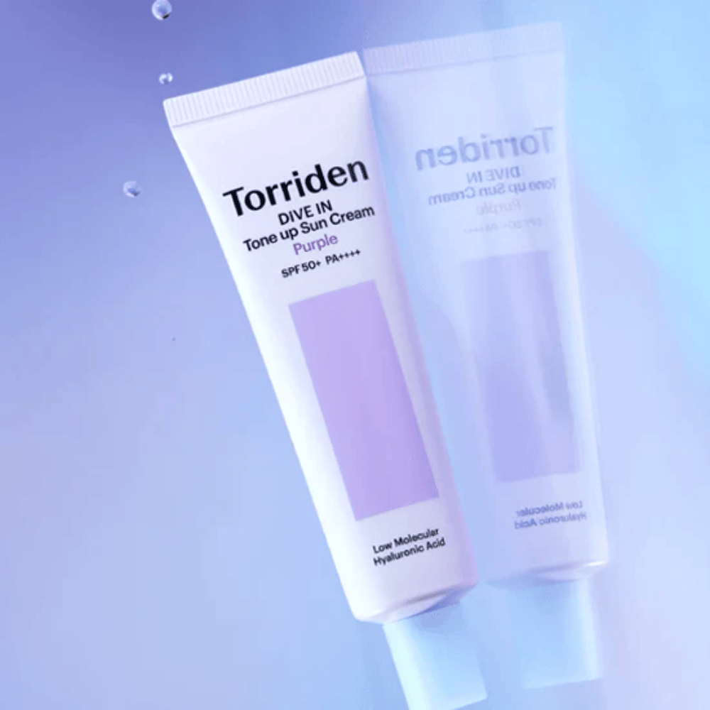 Torriden DIVE IN Tone Up Sun Cream Purple SPF50+ PA++++ photographed against a soft purple background that highlights the product's light-reflecting design.