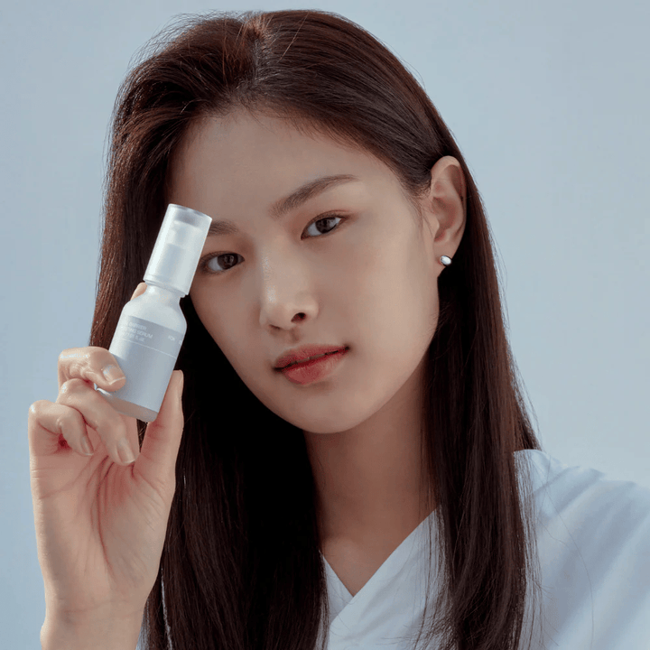 Model holding Celimax Dual Barrier Boosting Serum, Korean skincare that strengthens the skin barrier and soothes sensitive skin.