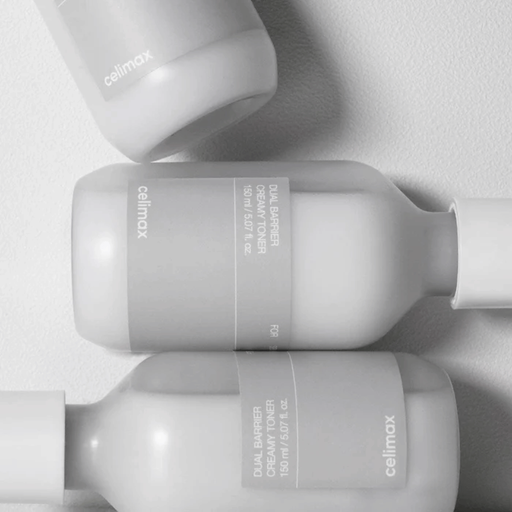 Three lying bottles of Celimax Dual Barrier Creamy Toner in a minimalist design with gray label and soft light – perfect for sensitive and dry skin.