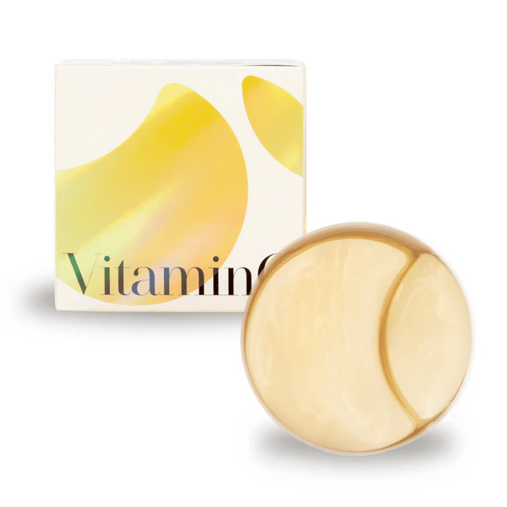 K-Secret Extra Illuminating Eye Gel Patches med vitamin C i guldskimrande hydrogel, burk och förpackning i bakgrunden.