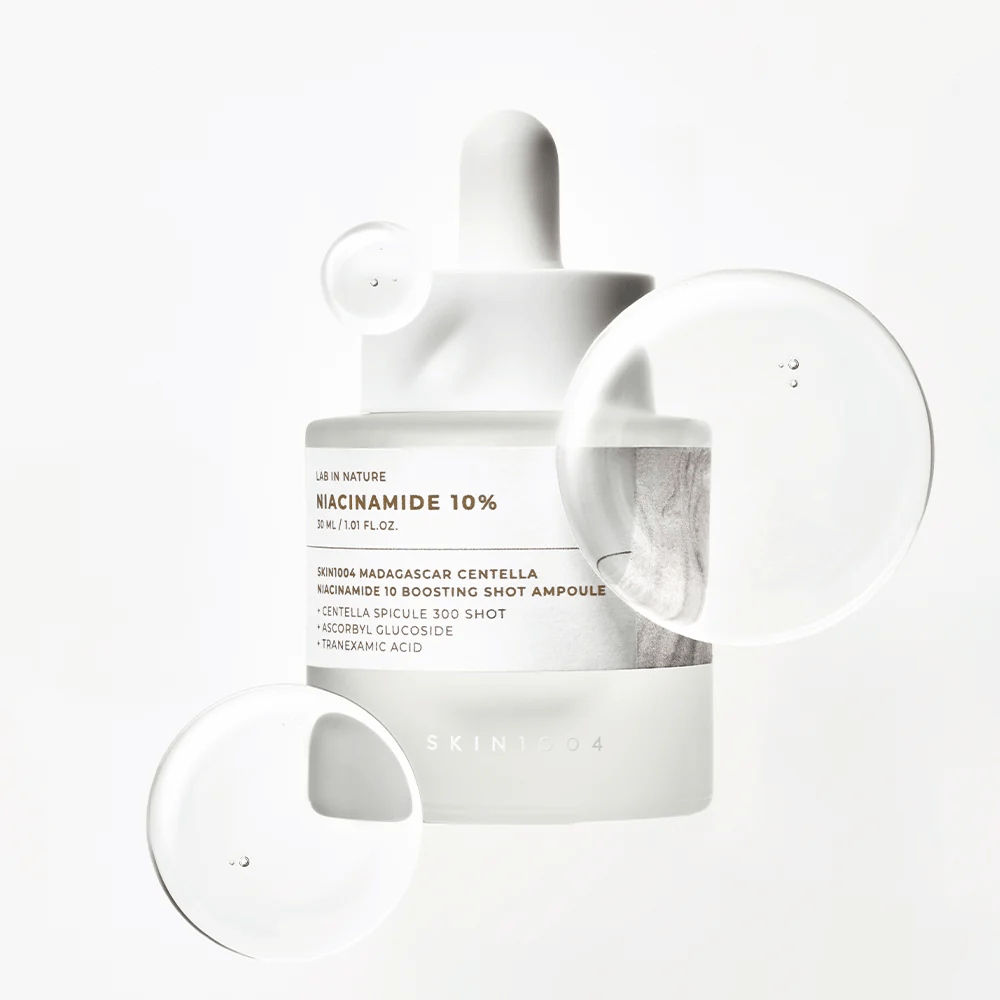 SKIN1004 Madagascar Centella Niacinamide 10 Boosting Shot Ampoule with serum drops showcasing a light, fast-absorbing formula with niacinamide, tranexamic acid, and centella.
