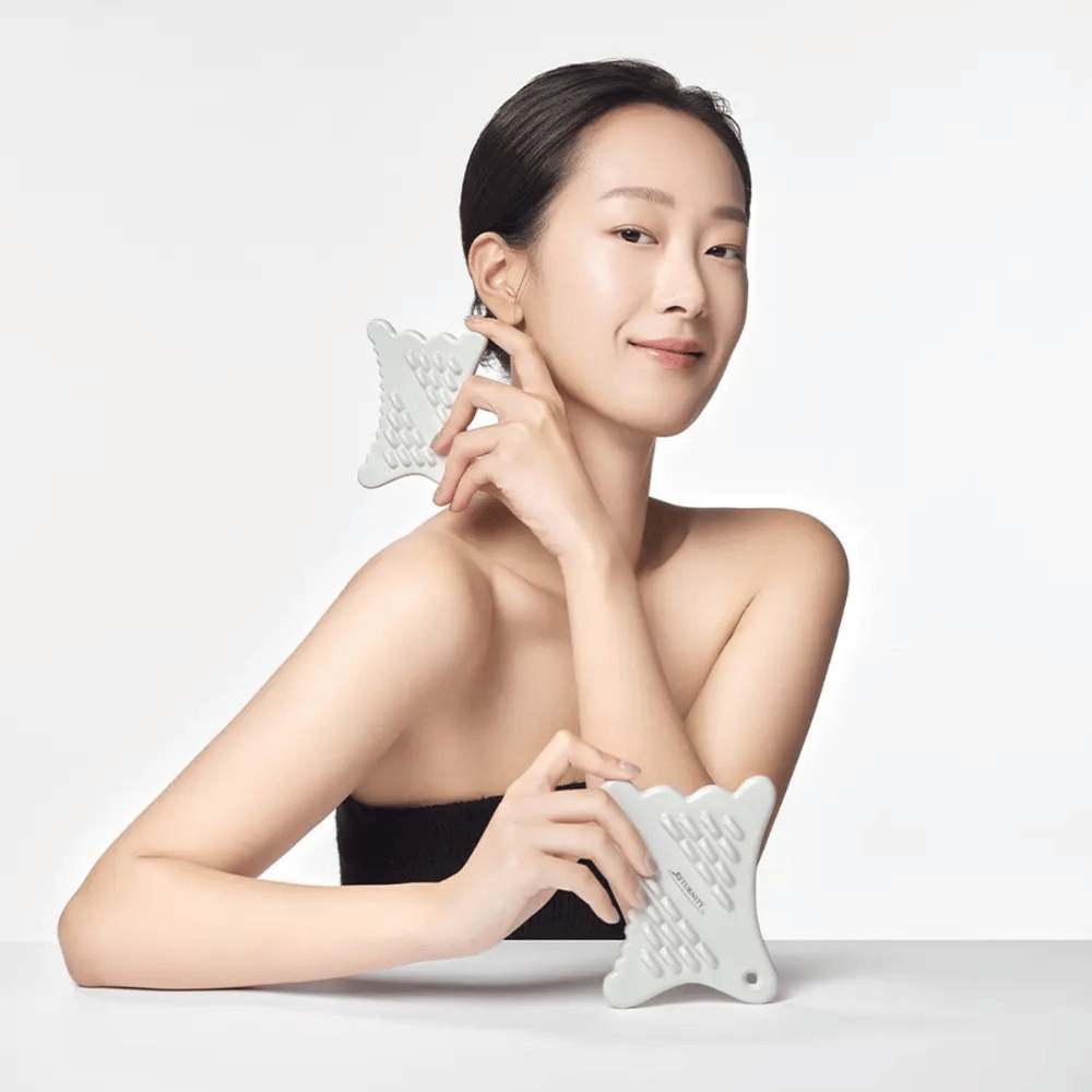 Model using RETURNITY Mini Guasha along the jawline for facial massage and skincare routine.