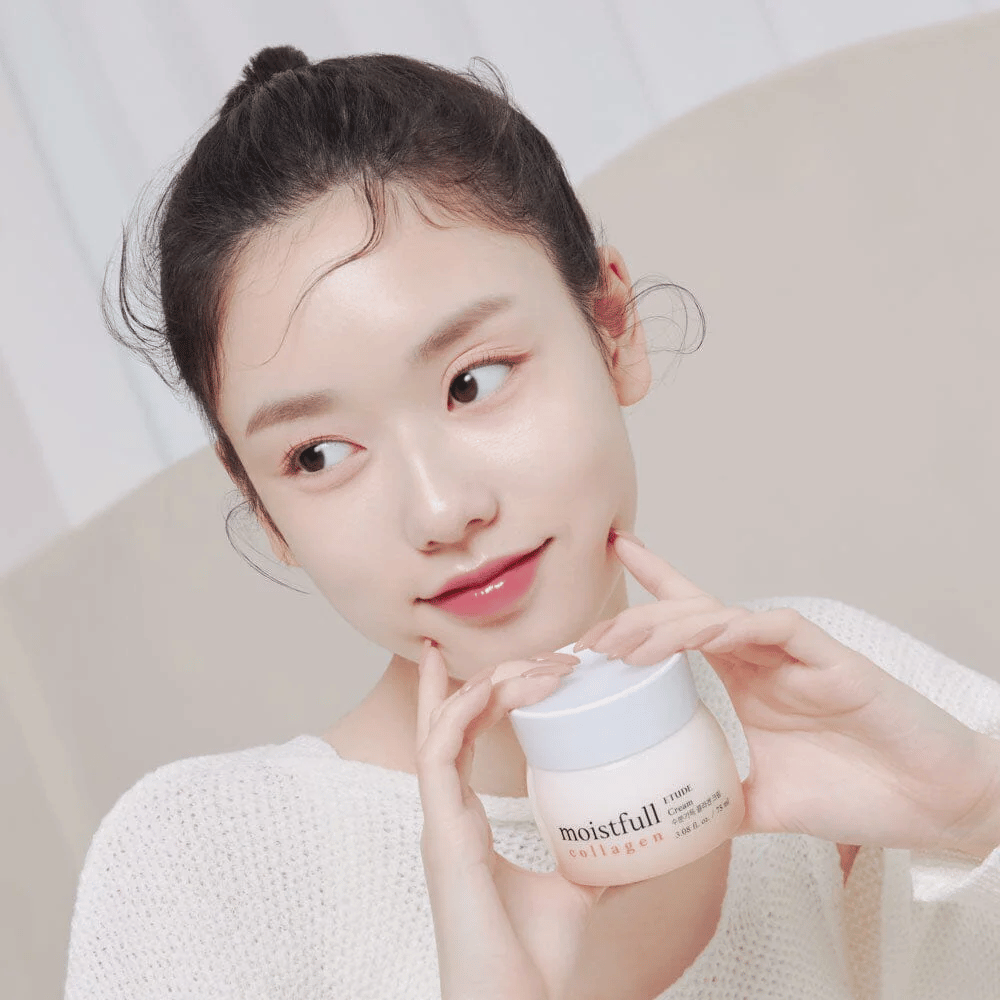 Woman holding a jar "Moistfull Collagen Cream", white shirt, smiling.