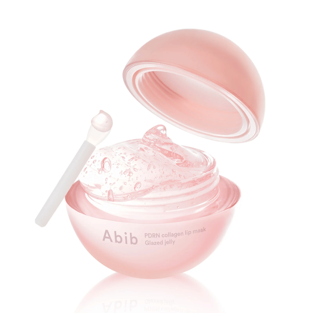 Pink round jar with Abib PDRN Collagen Lip Mask Glazed Jelly, open with the lid tilted back. Transparent gel with air bubbles is visible in the jar along with a small spatula.