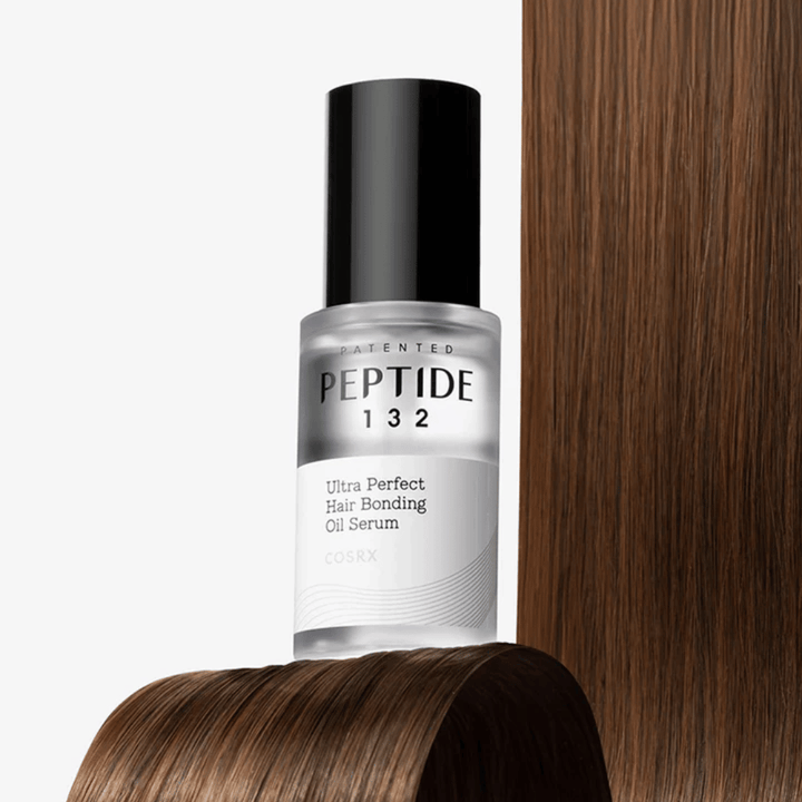 COSRX Peptide 132 Ultra Perfect Hair Bonding Oil Serum placerad mot glansigt hår – ger styrka, mjukhet och glans.