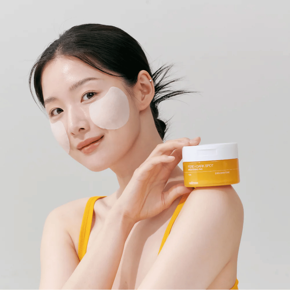 Woman applies Celimax Pore + Dark Spot Brightening Pad – Korean pads that even out the skin tone and reduce pores and pigmentation spots.