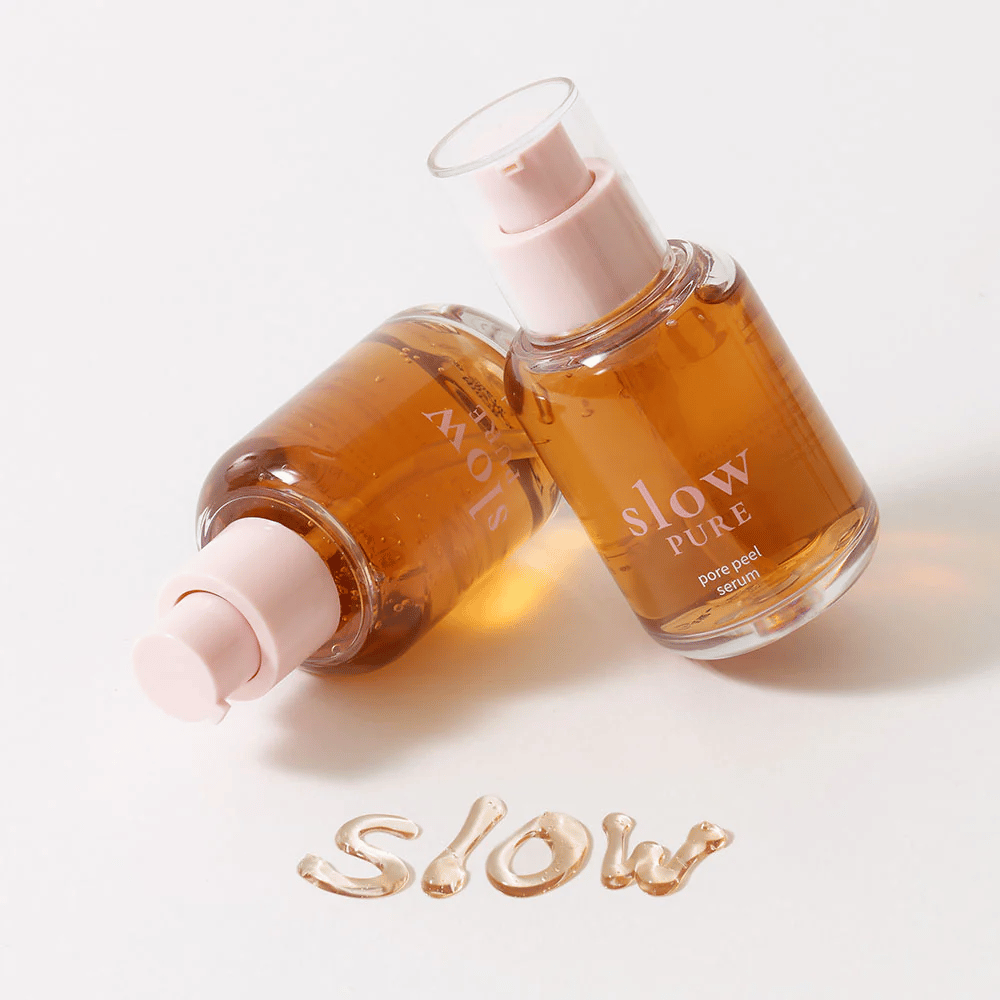 Two bottles of Slow Pure Pore Peel Serum with pump, text written in serum on the surface: "Slow".