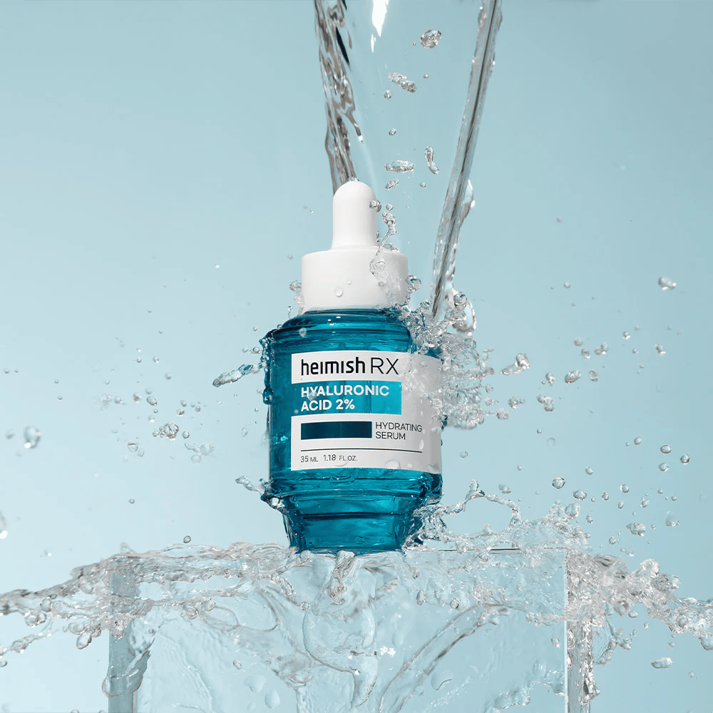 Heimish RX Hyaluronic Acid 2% Hydrating Serum placed on an ice-like surface with water splashing around, symbolizing intensive hydration and freshness.