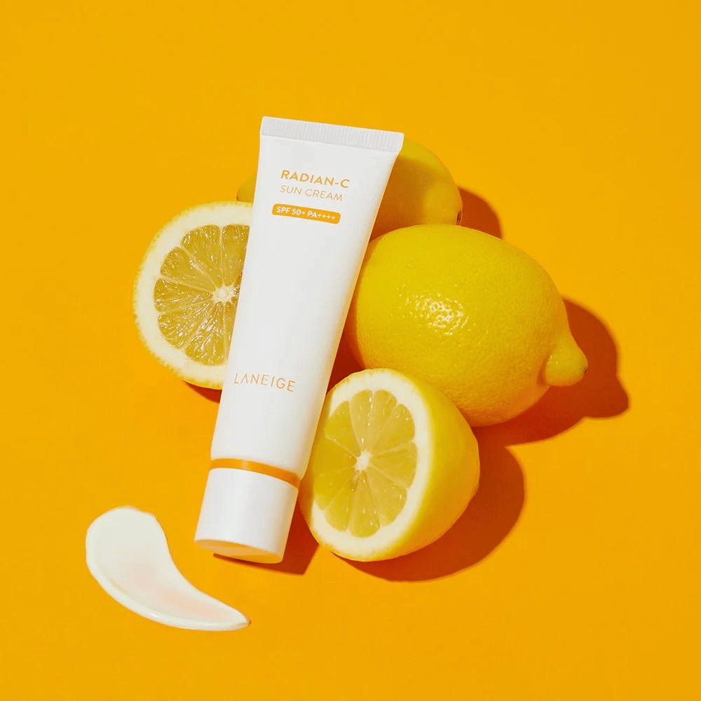 LANEIGE Radian-C Sun Cream SPF 50+ PA++++ with lemons and a dab of sunscreen on a vibrant yellow background.
