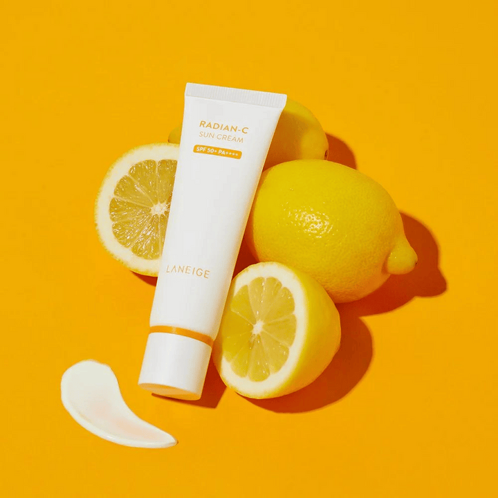 LANEIGE Radian-C Sun Cream SPF 50+ PA++++ med citroner och en klick solkräm på en färgstark gul bakgrund.