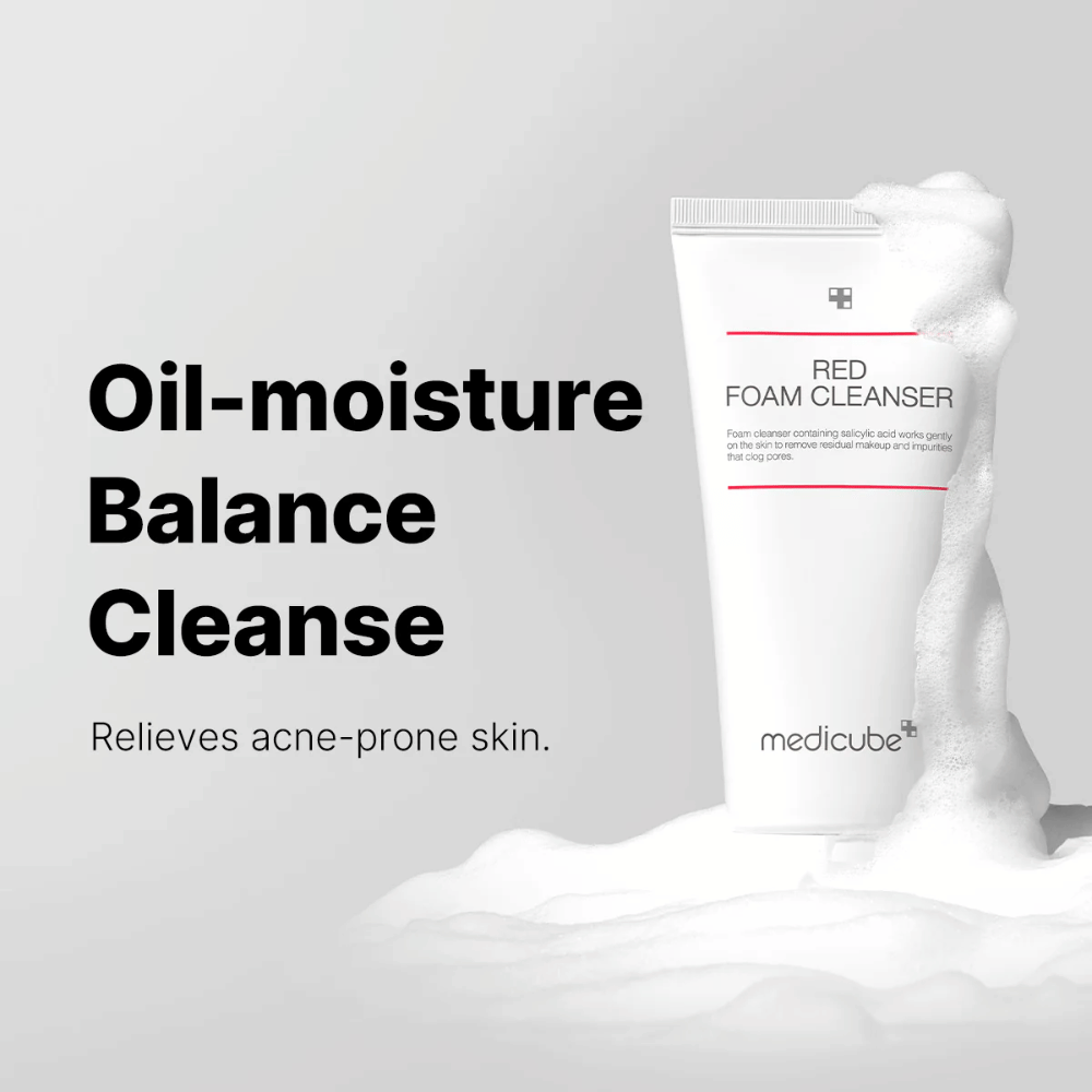Tube with Medicube Red Foam Cleanser standing upright among foaming lather. The text "Oil-moisture Balance Cleanse" is shown to the left, with the description "Relieves acne-prone skin" underneath. The background is light gray.