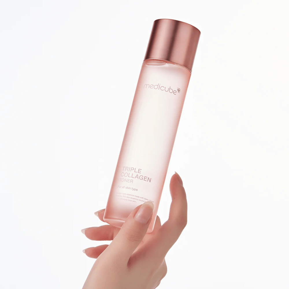 Hand holding a pink bottle of Medicube Triple Collagen Toner 4.0, a moisturizing and firming toner for all skin types.