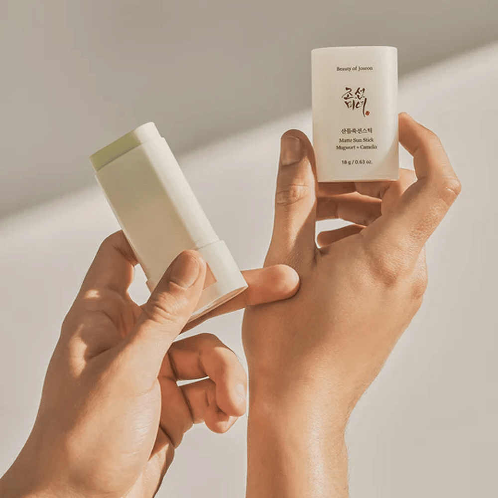 Two hands holding a stick of Beauty of Joseon's Matte Sun Stick 18g SPF50 PA++++.
