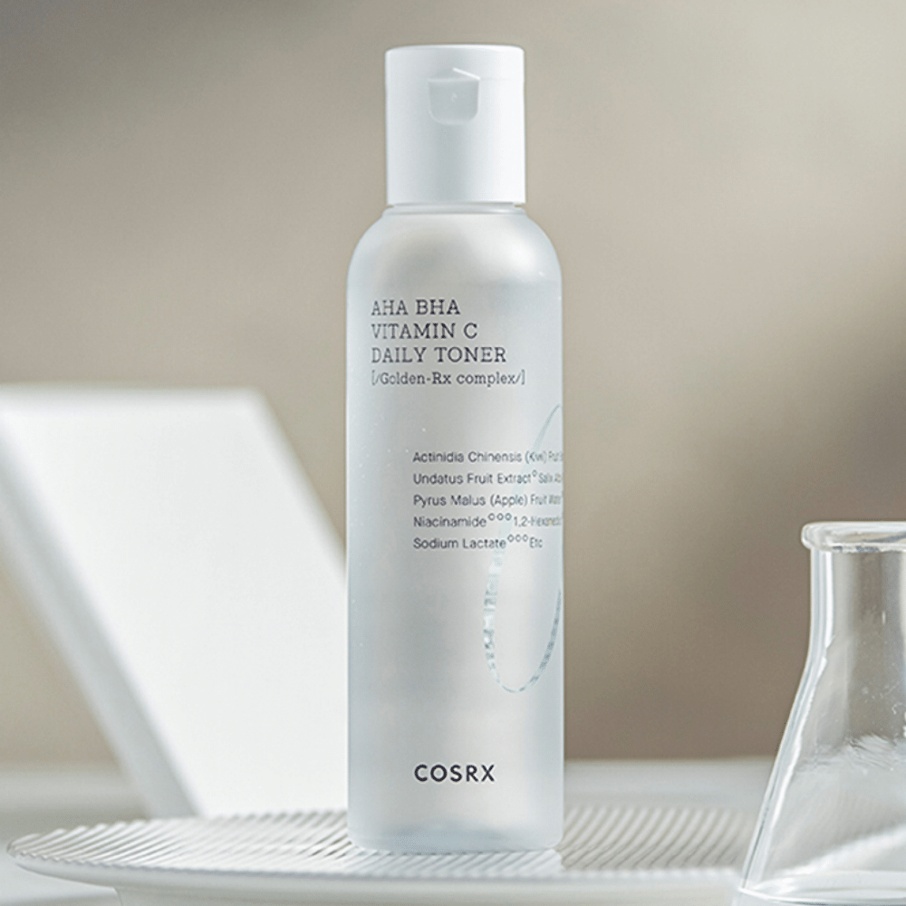 A bottle COSRX Refresh AHA BHA Vitamin C Daily Toner 150ml sitting on top of a white plate.