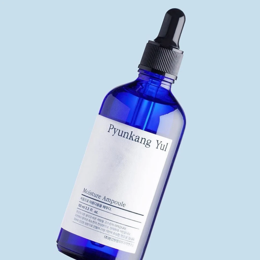 A blue bottle on a blue background with Pyunkang Yul's Moisture Ampoule 100ml serum.