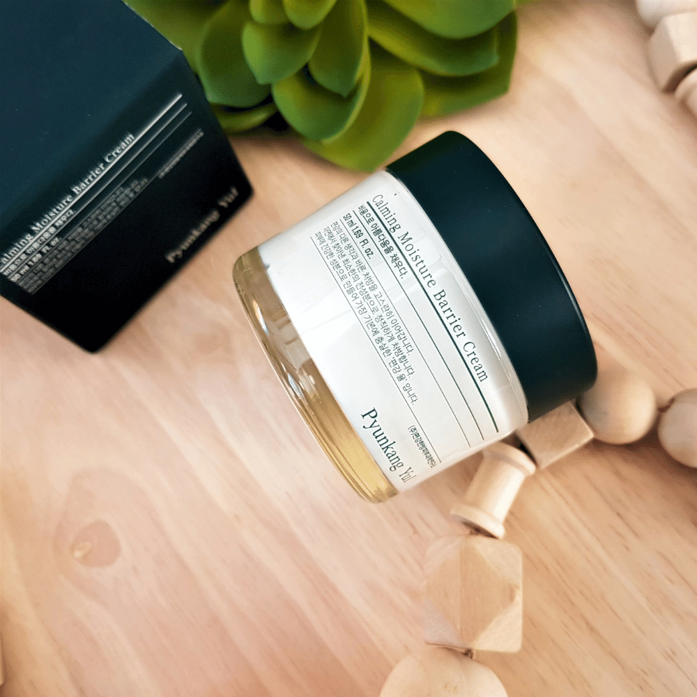A jar Pyunkang Yul Calming Moisture Barrier Cream 50ml sitting on top of a wooden table.